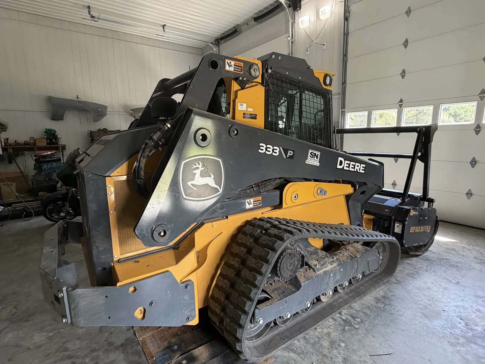 Rear view of the track loader with the mulching head attached