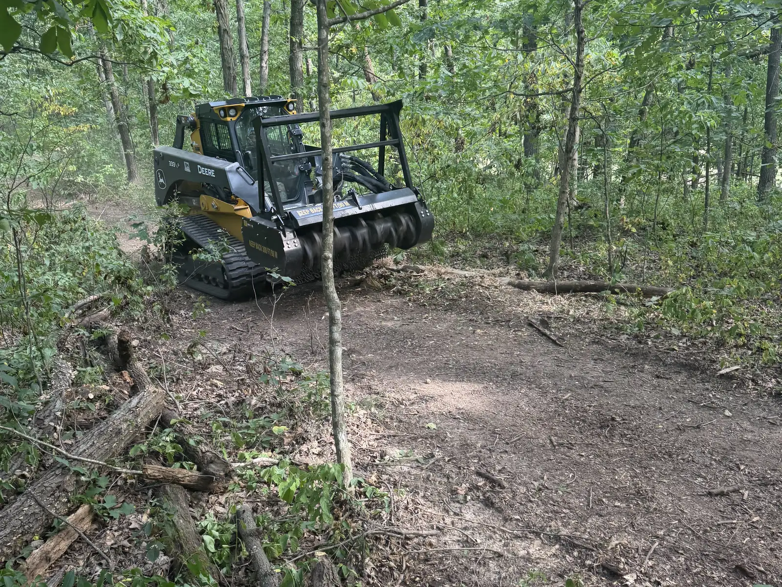 Forestry mulcher opening a trail through hardwood timber